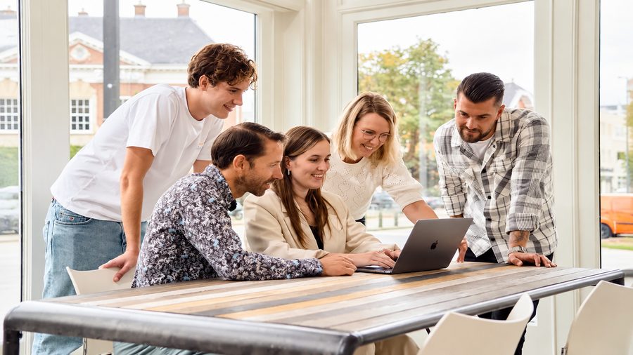 Petite équipe de professionnels réunie autour d'un ordinateur portable
